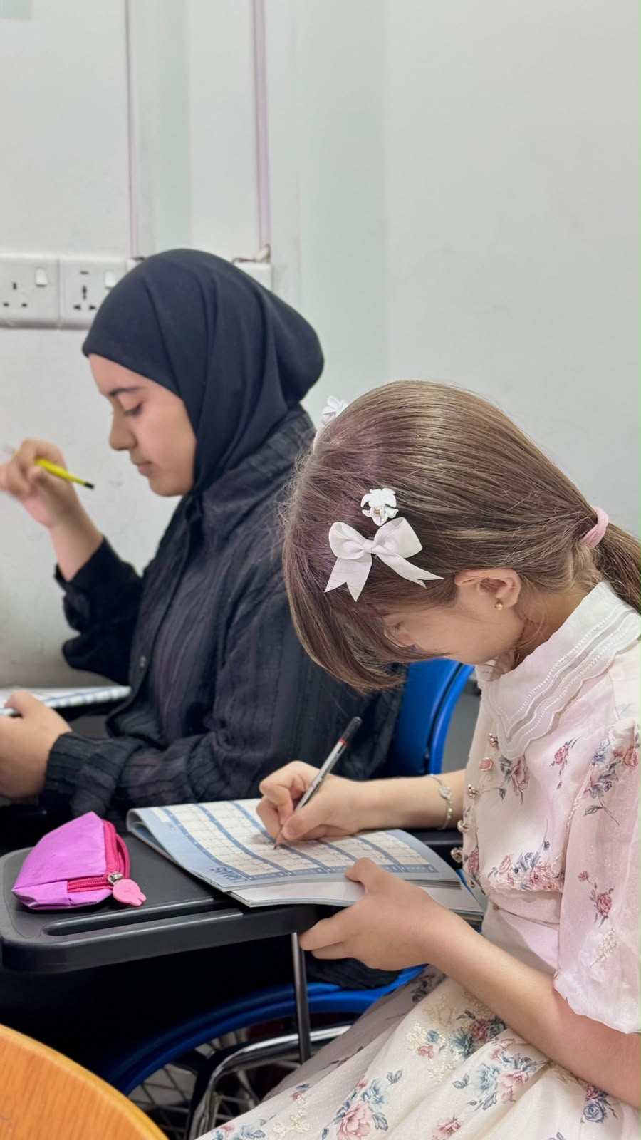 طالبتان تتعلمان معًا داخل الصف