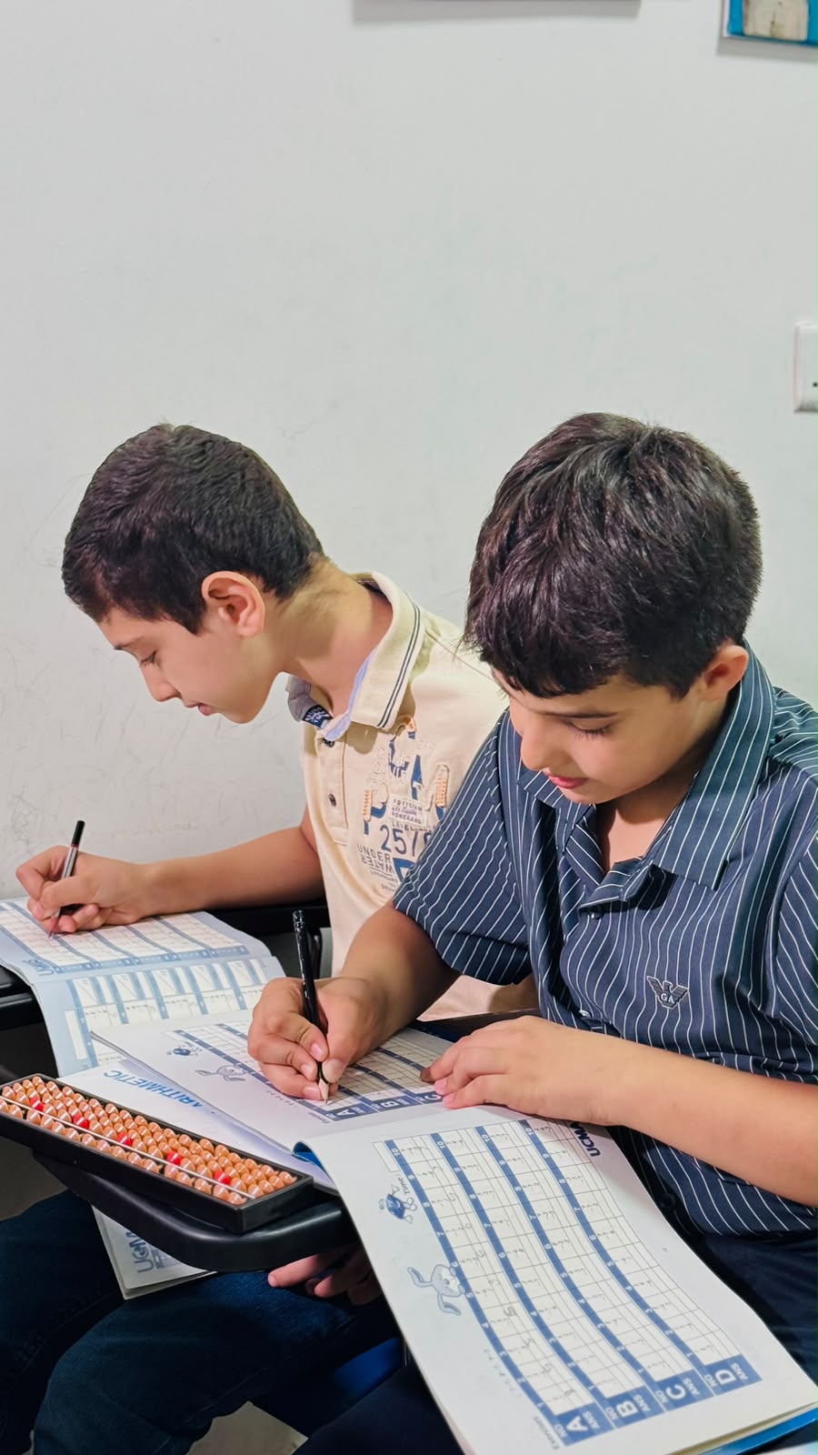 طالبان يتدربان على الحساب باستخدام المعداد