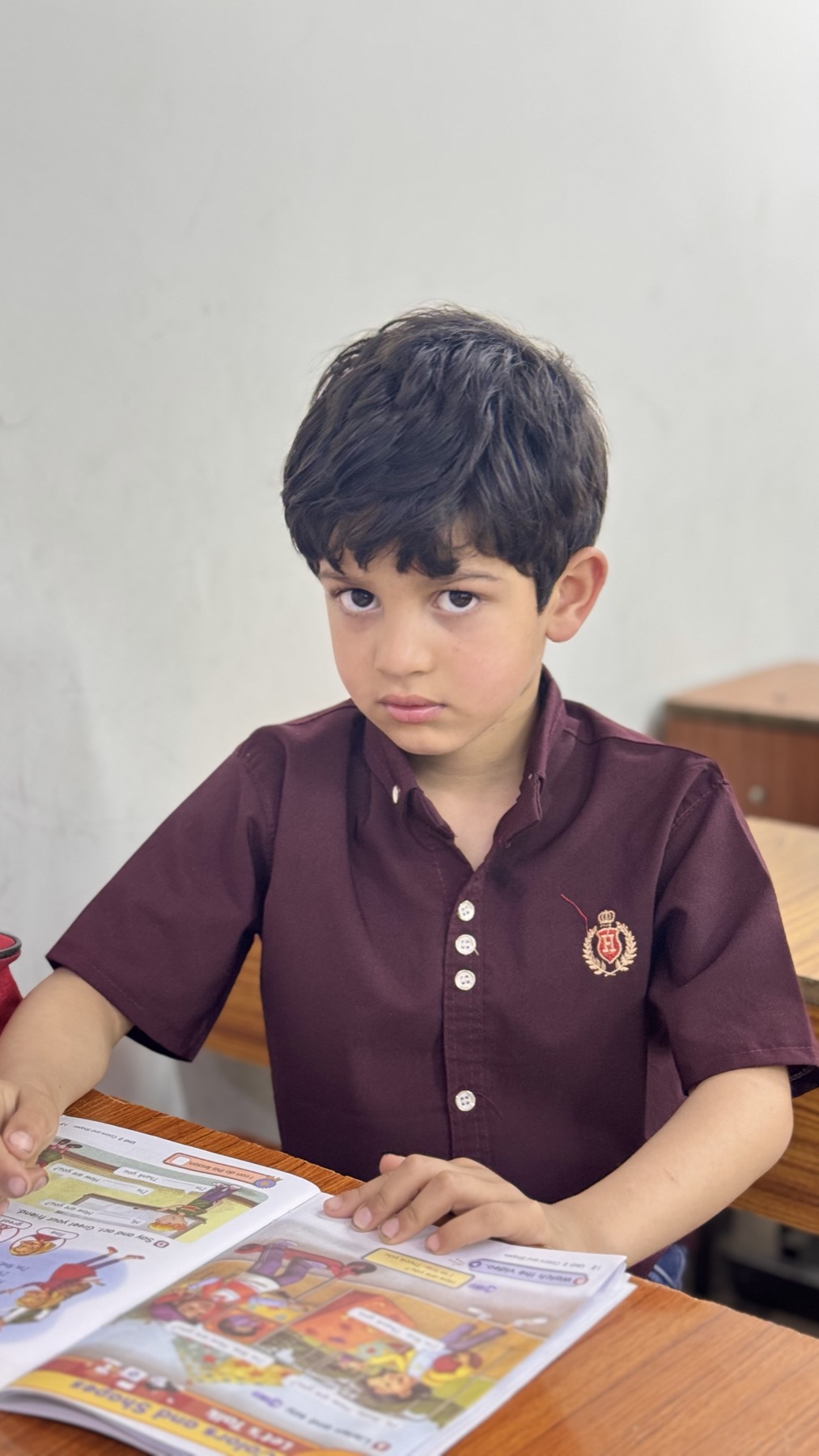 طالب بزي المعهد يحمل كتاب اللغة الإنجليزية