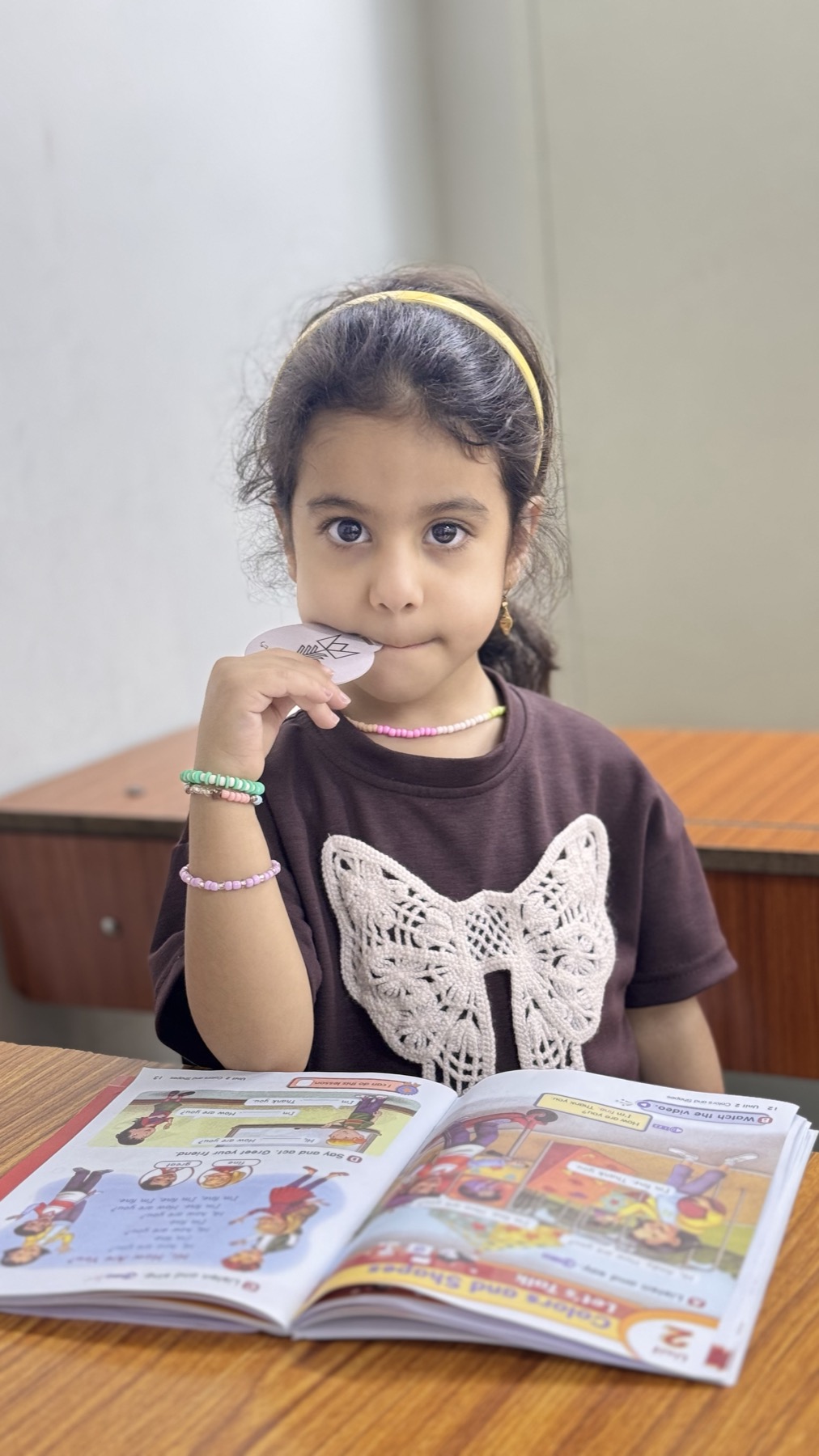 طالبة صغيرة مع كتاب تمارين اللغة الإنجليزية