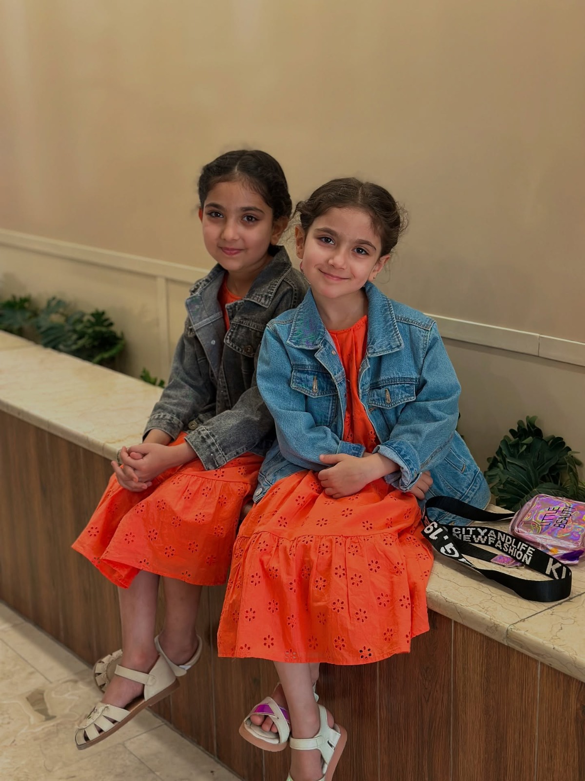 طالبتان صغيرتان بجانب مدخل المعهد