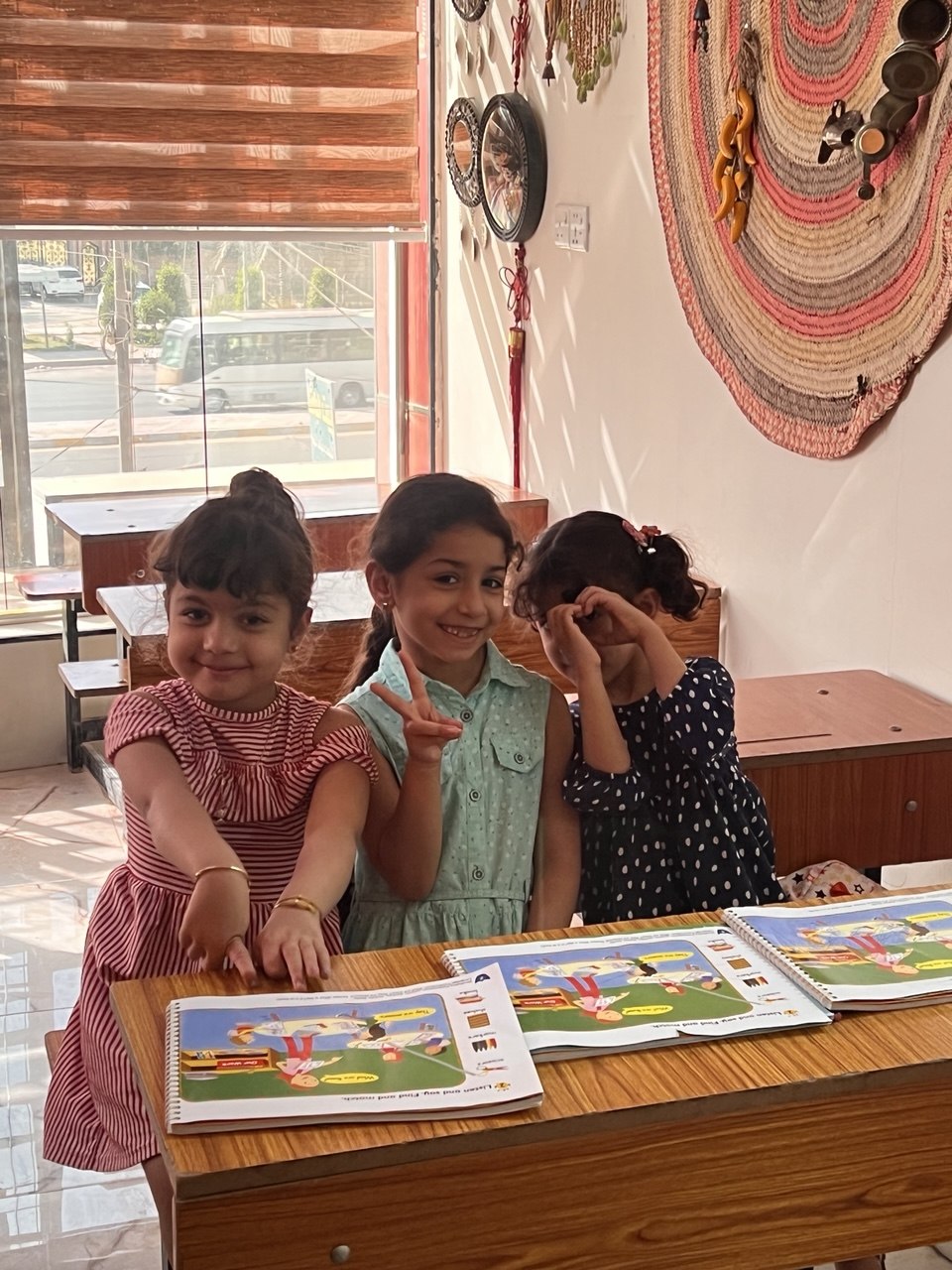 طالبات صغيرات مع كتب تمارين اللغة الإنجليزية