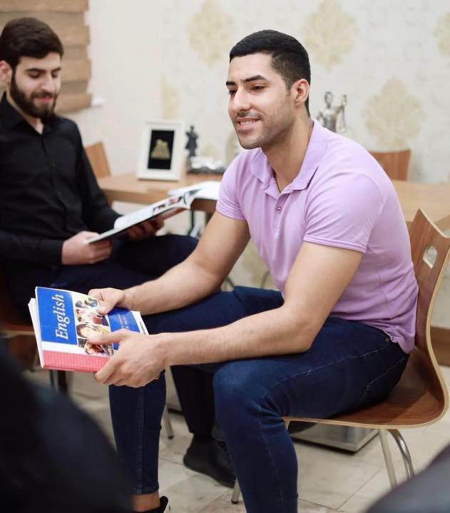 طلاب يطالعون كتاب اللغة الإنجليزية معاً