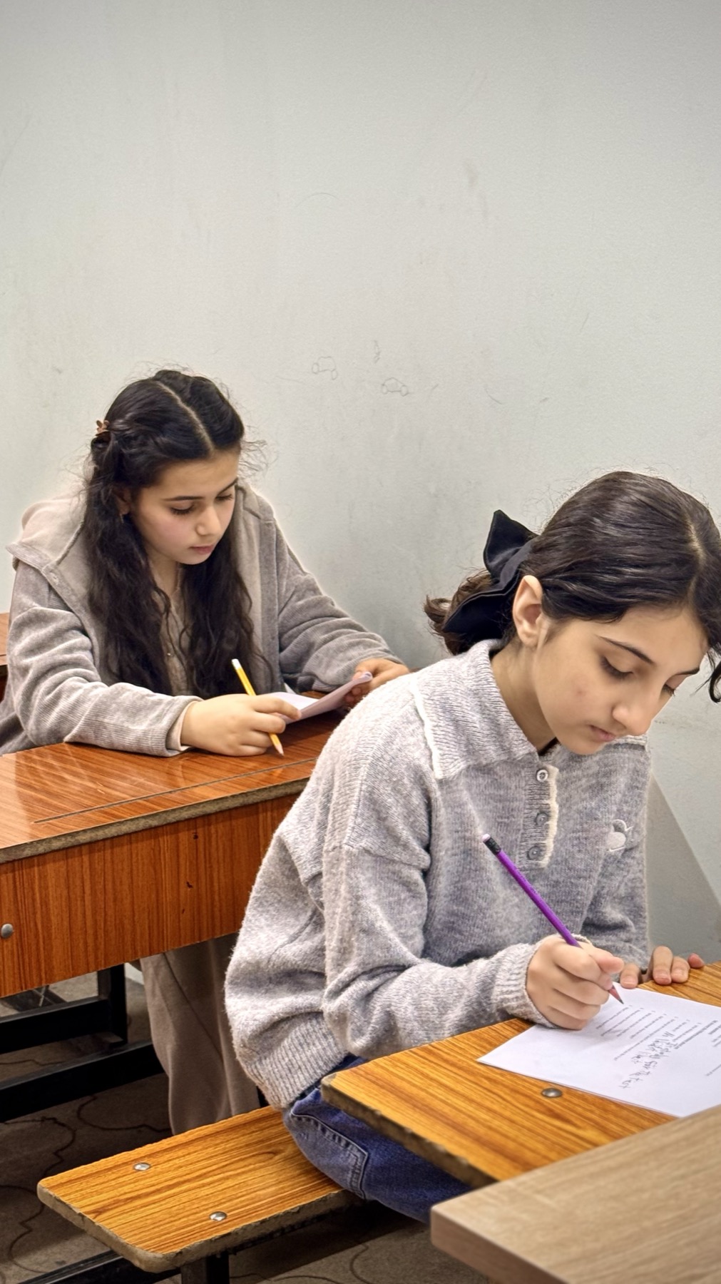 طالبتان تكتبان بدفاترهما أثناء المحاضرة